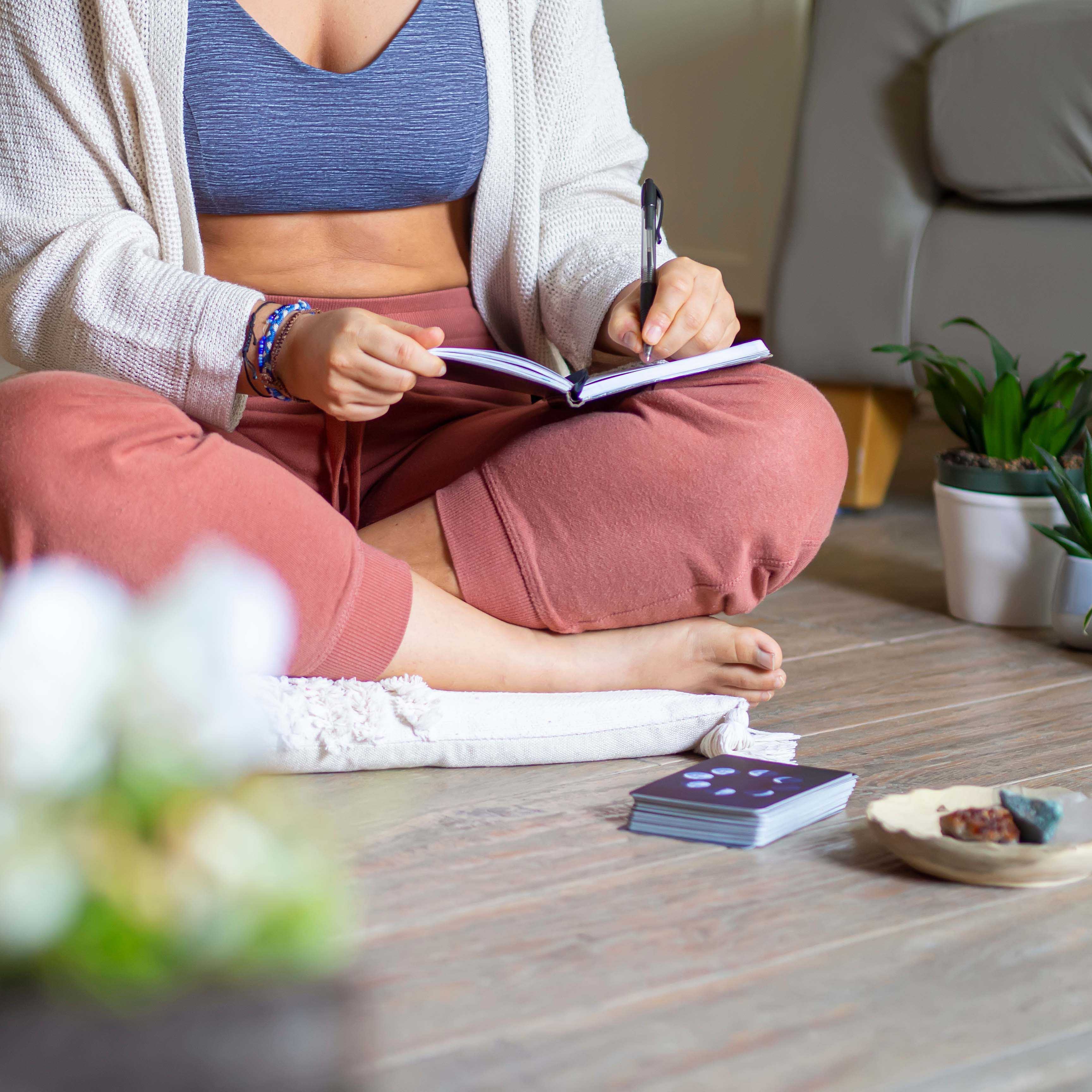 Woman journaling and manifesting in a diary as a routine at home